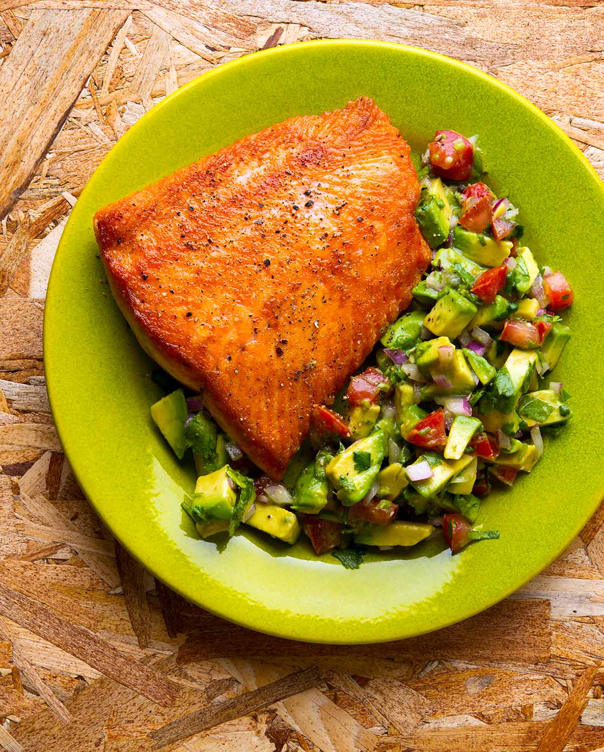 Seared salmon with avocado salsa on a plate