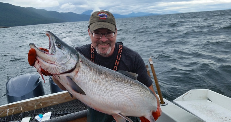 Hank Shaw holding a very large coho salmon. 