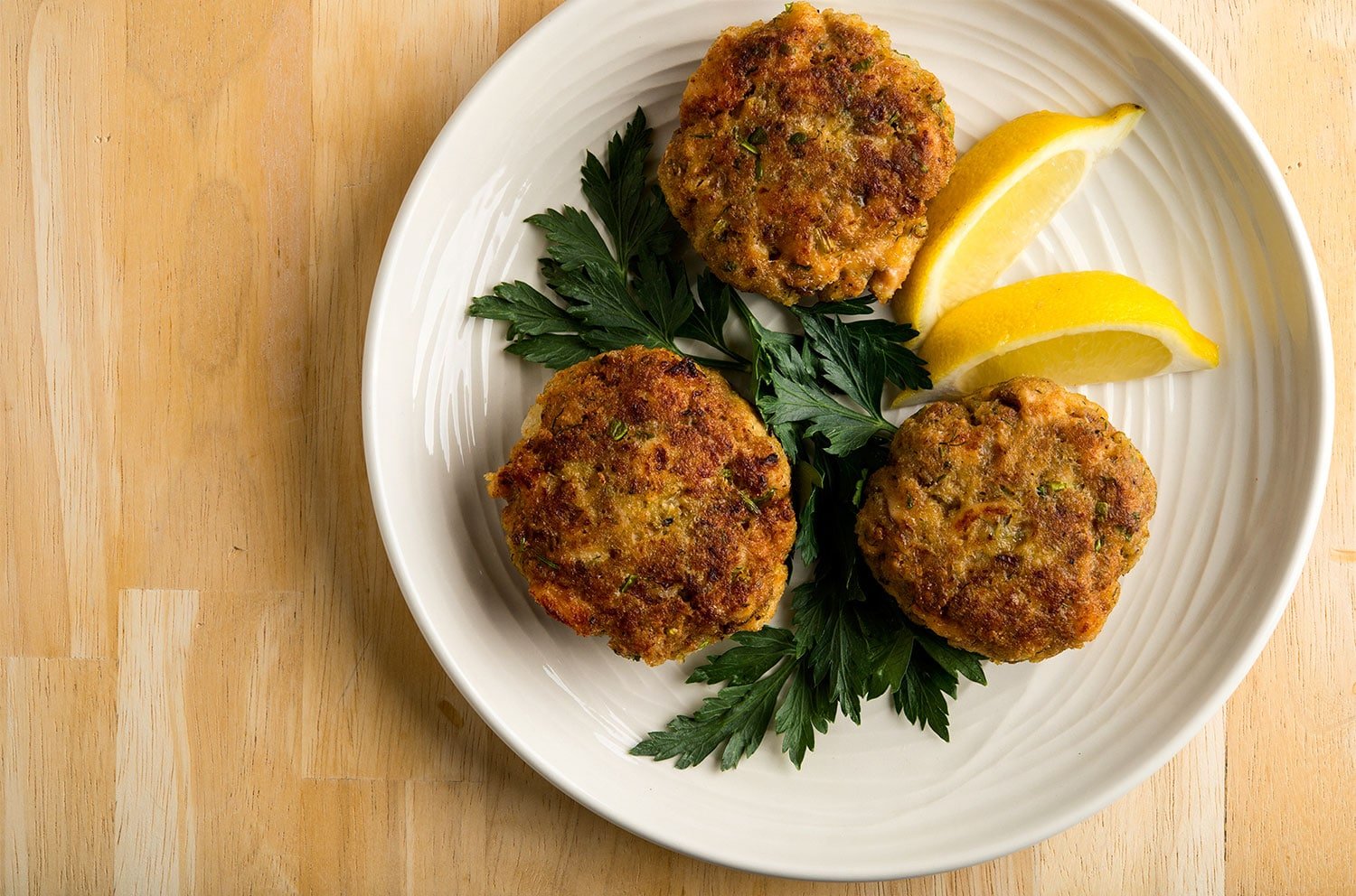 trout cakes on a plate with lemon