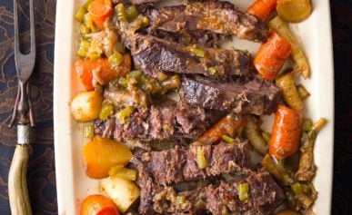 Venison pot roast made in a crock pot, served on a platter.