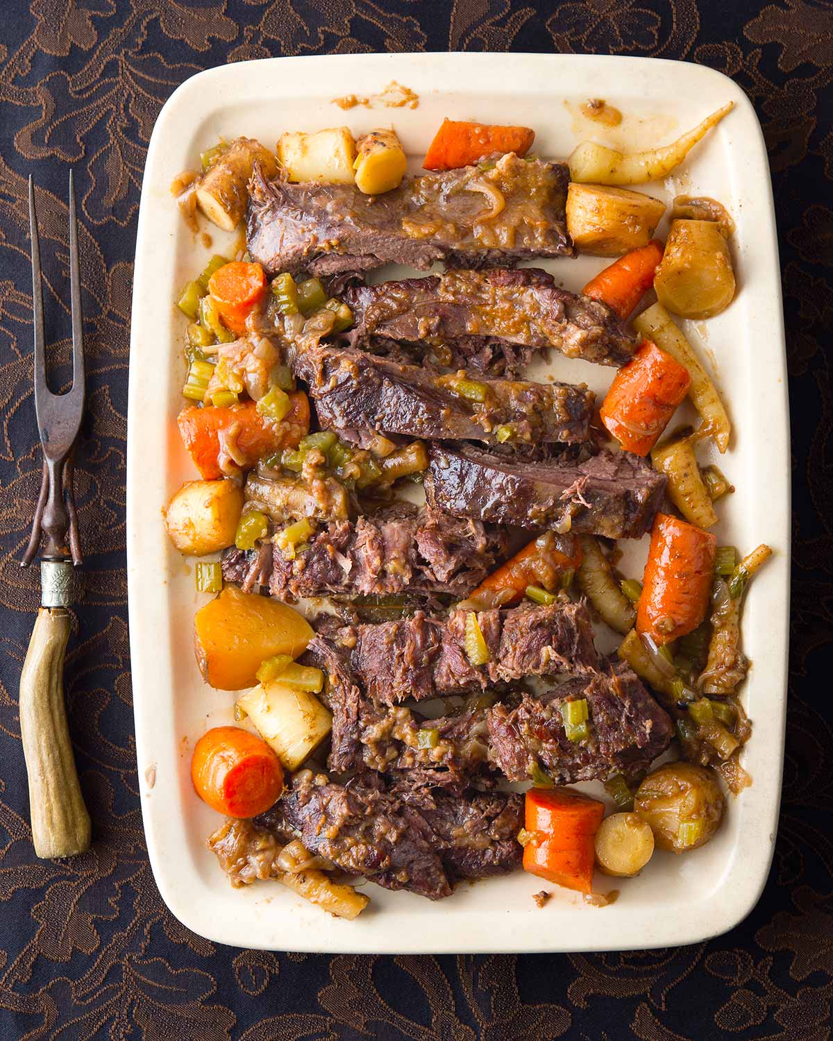 Venison pot roast made in a crock pot, served on a platter.