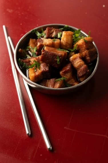 Chinese red pork in a bowl with chopsticks