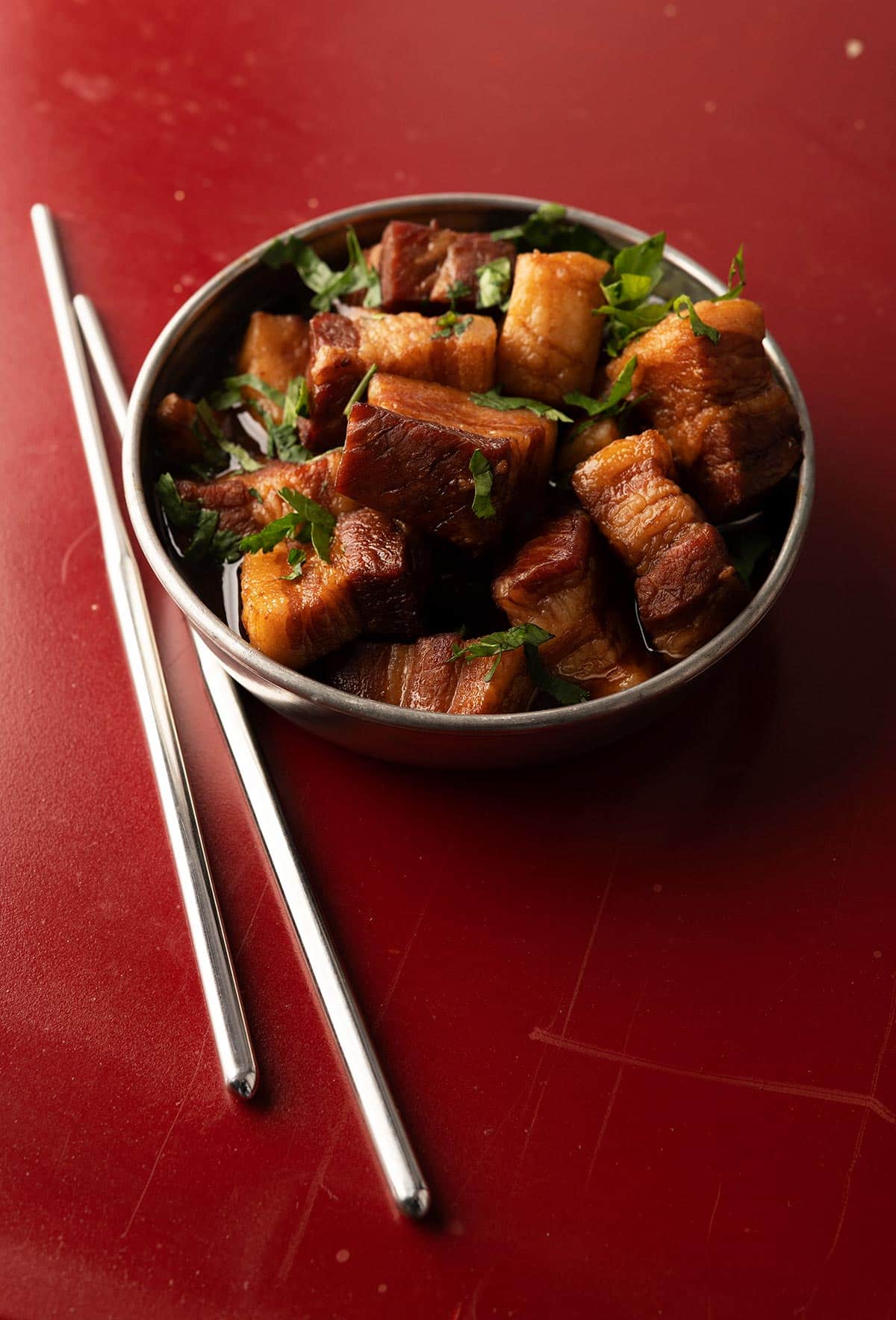 Chinese red pork in a bowl with chopsticks