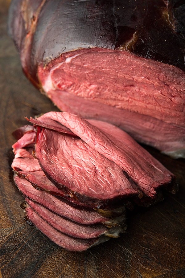 Smoked venison leg sliced on a cutting board