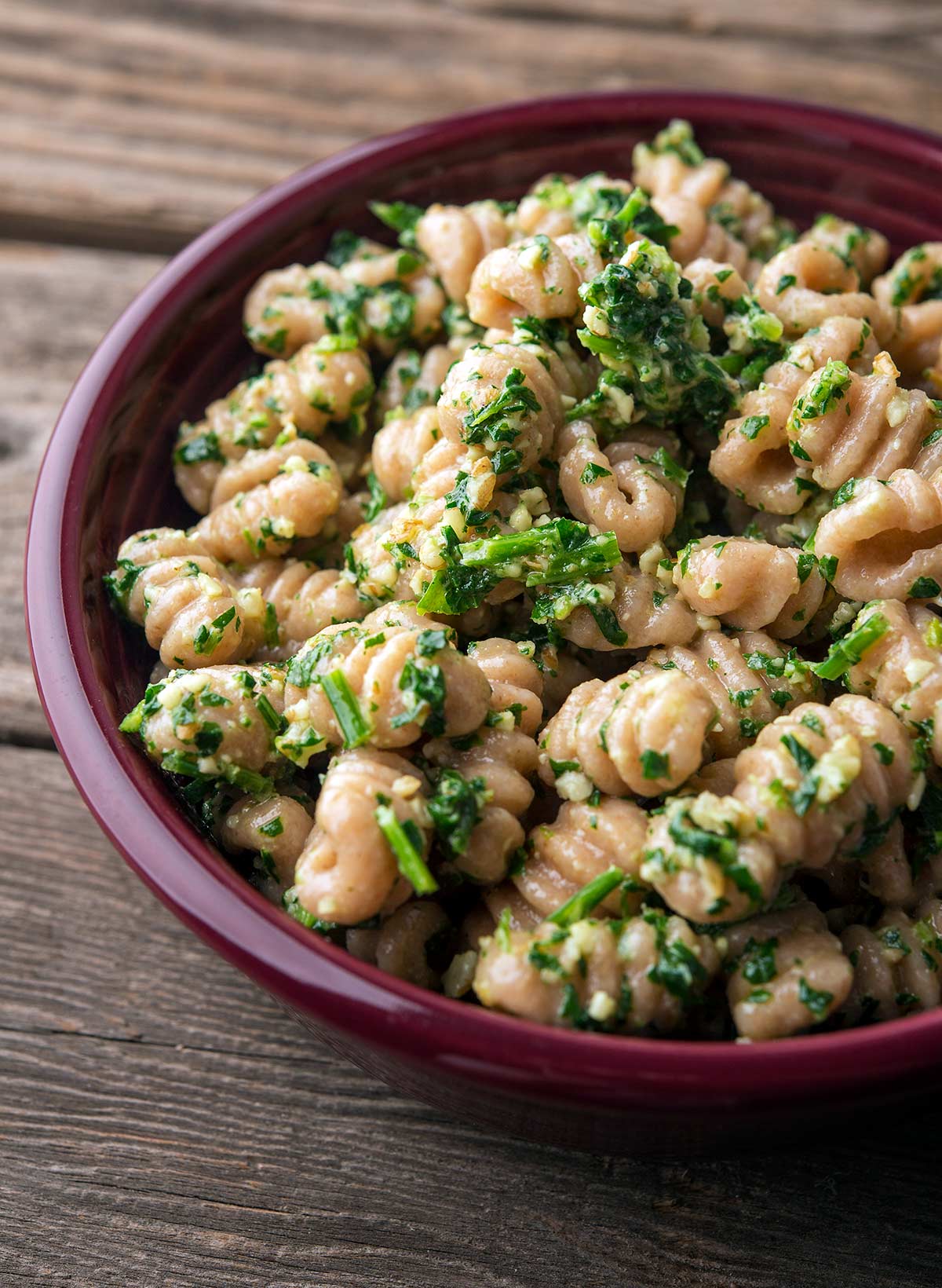 Parsley pesto mixed with pasta in a bowl 