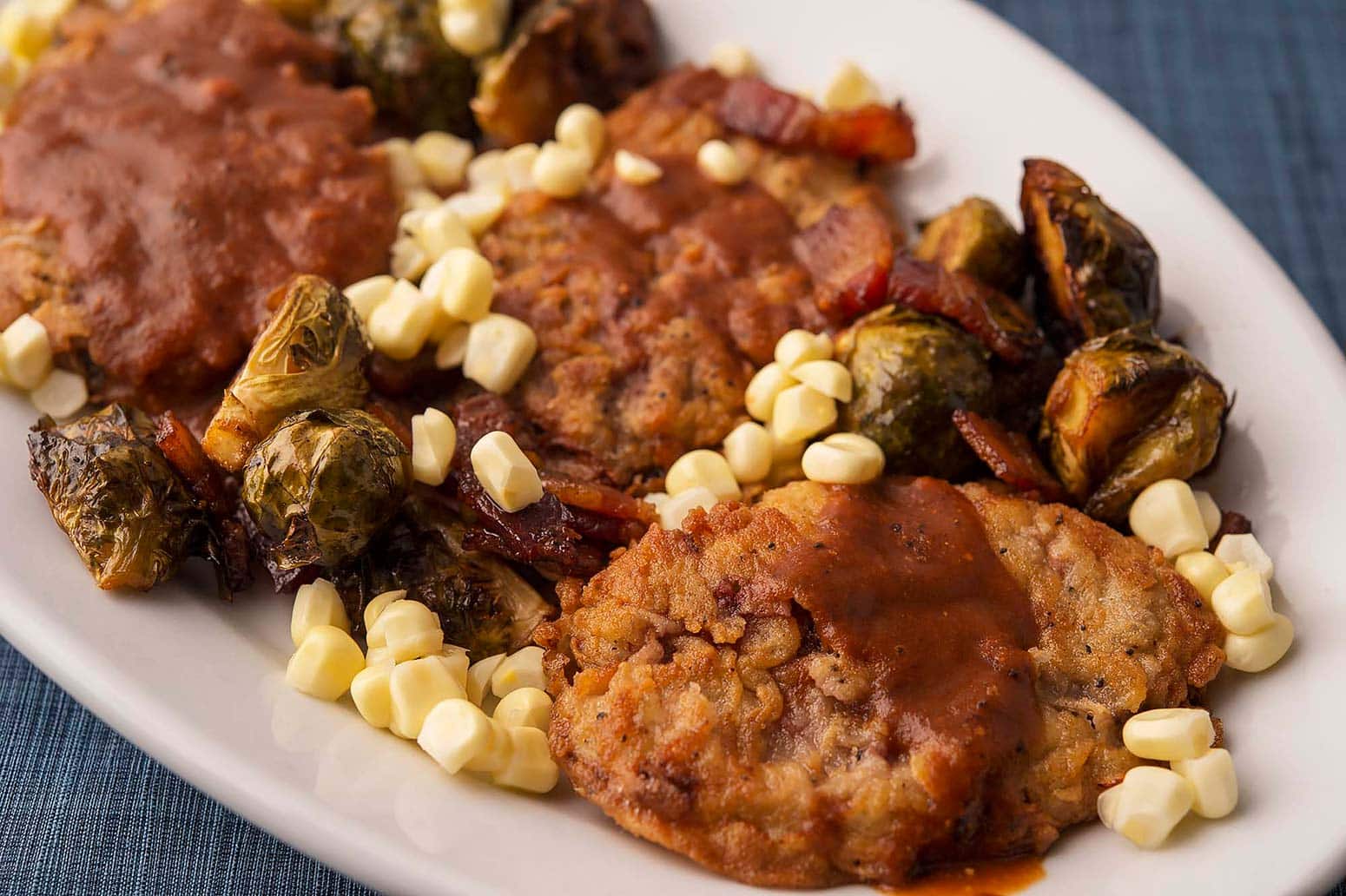 chicken fried duck with corn on a platter