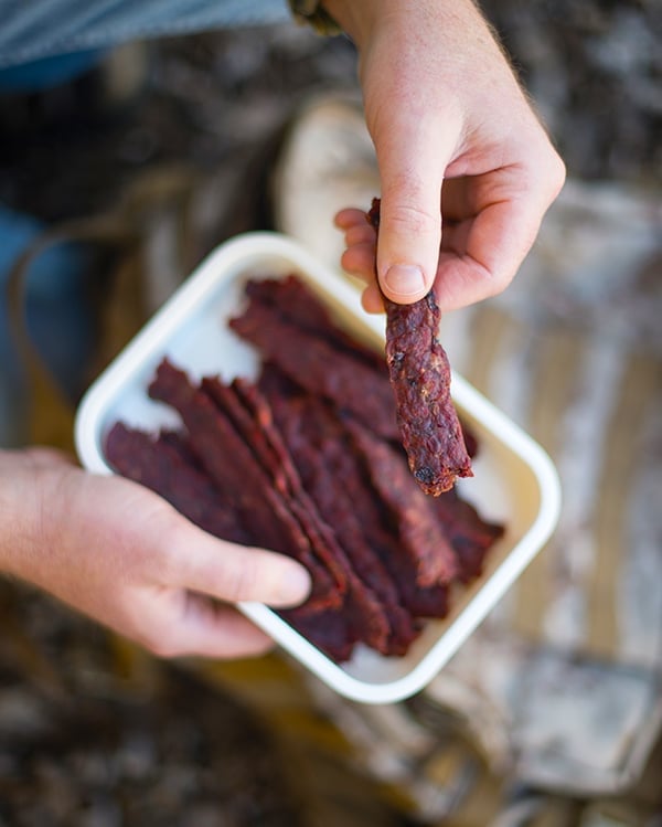 Hank Shaw holding a piece of ground venison jerky