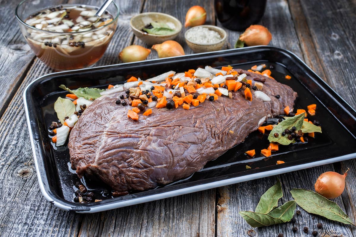 Venison sauerbraten marinating on a platter