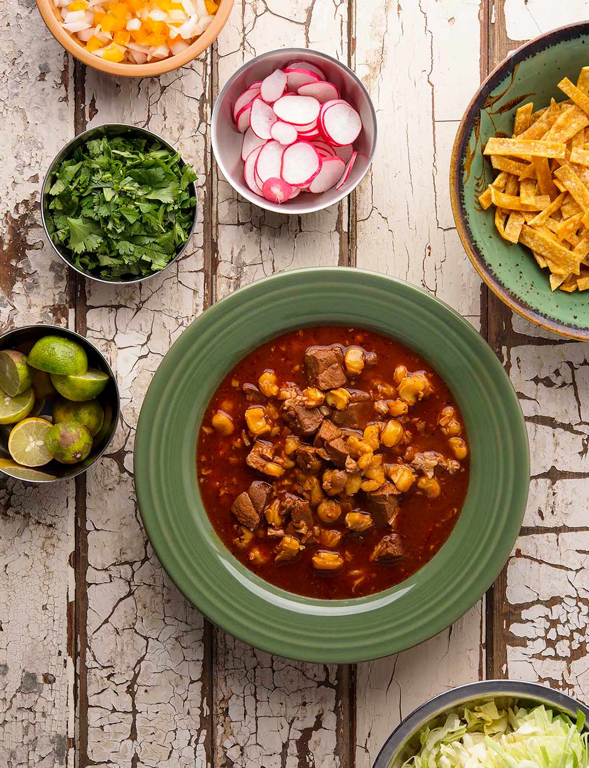 pozole rojo in a bowl with all the fixins