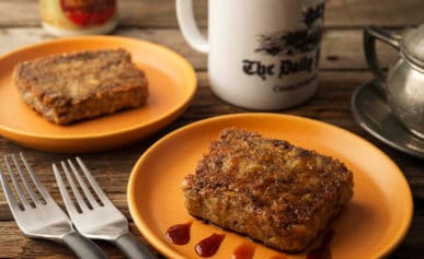 Two plates of scrapple with a cup of coffee.