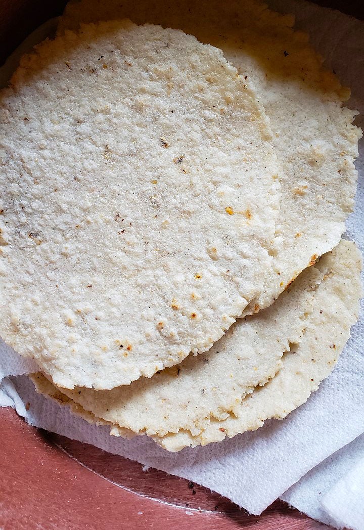Poorly made corn tortillas on a plate. 