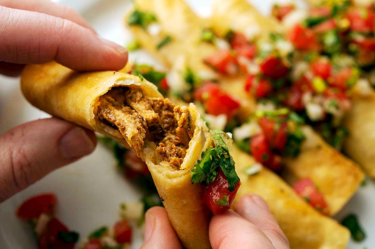 Breaking open a taquito to show filling