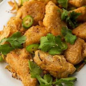 A close up of a plate of salt and pepper fish.