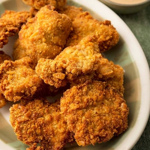 Chicken Strips Or Nuggets Being Deep-fried In A Cast-iron Frying