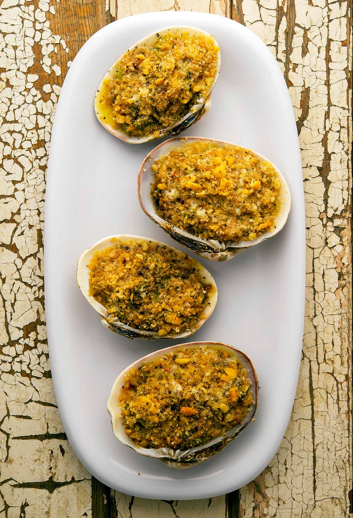 Four stuffed clams on a platter. 