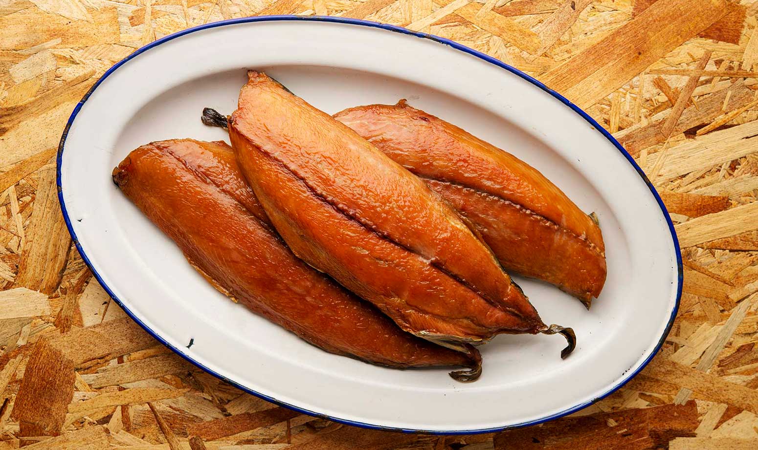 Three fillets of smoked bonito fish on a platter. 