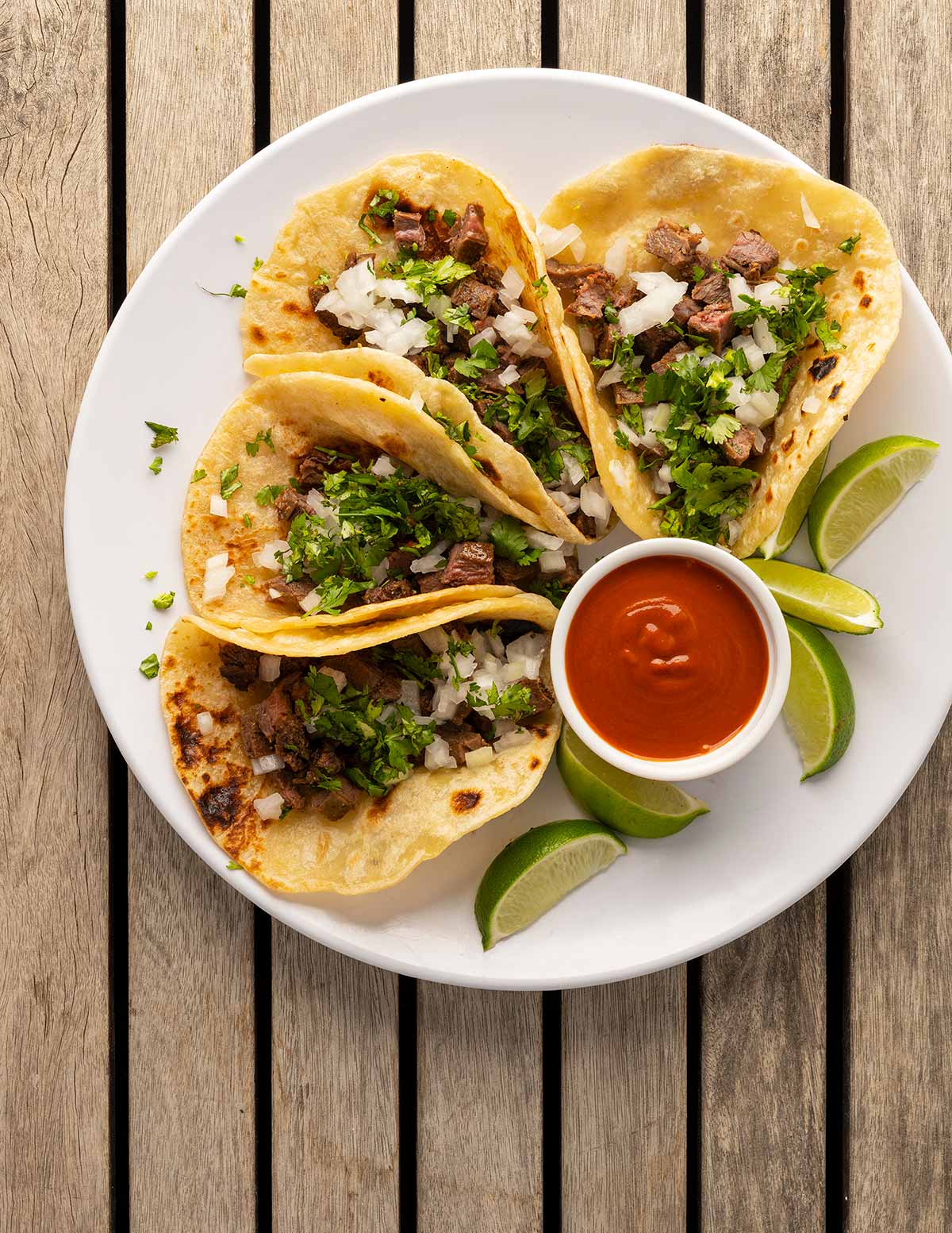 A plate of arrachera tacos with salsa