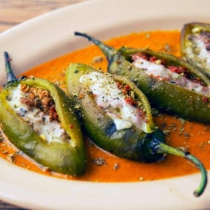 Sausage stuffed jalapenos with a tomato sauce.