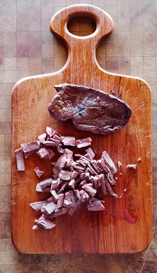 chopped goose breast on cutting board