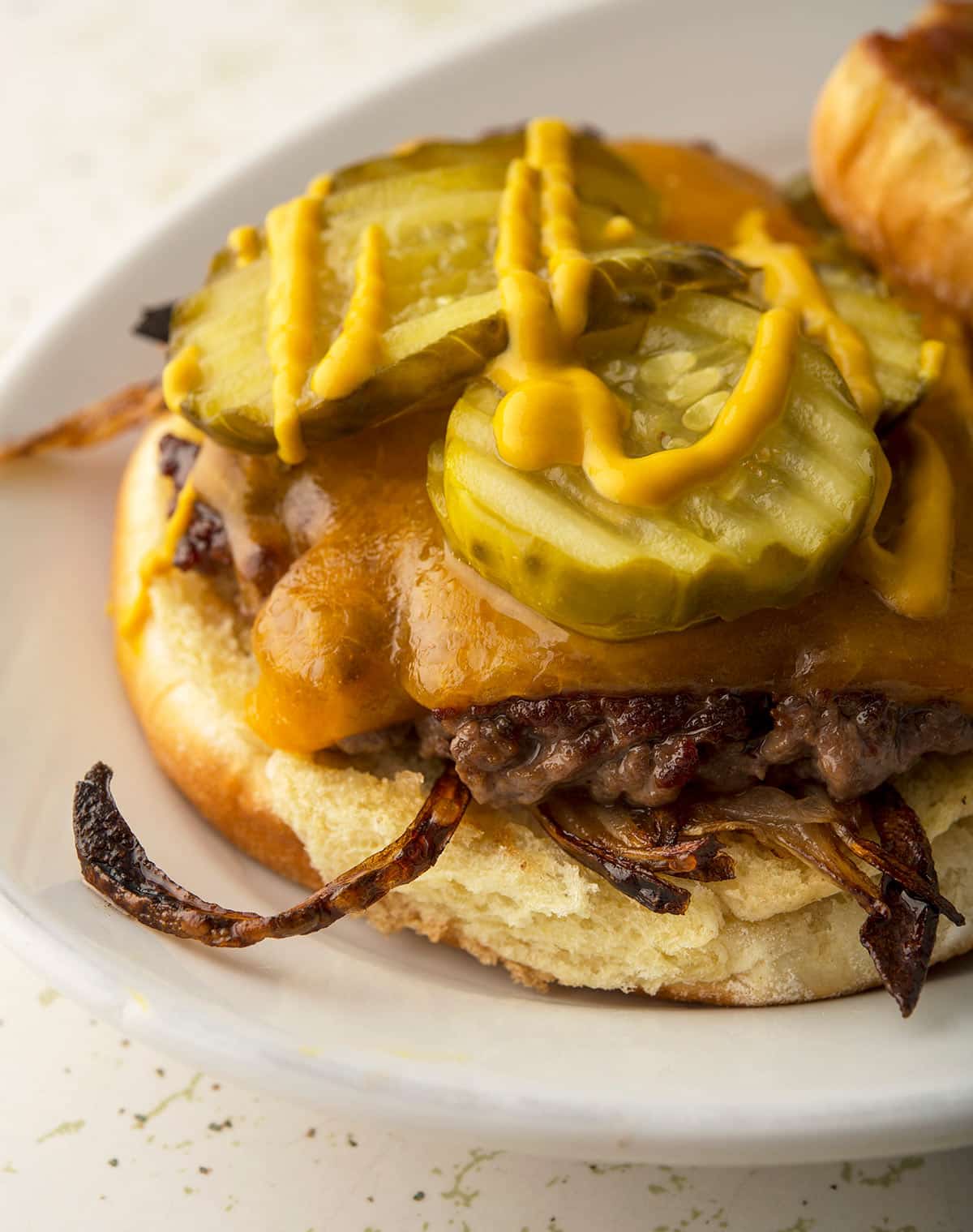 An onion burger with the top bun off, showing the insides. 