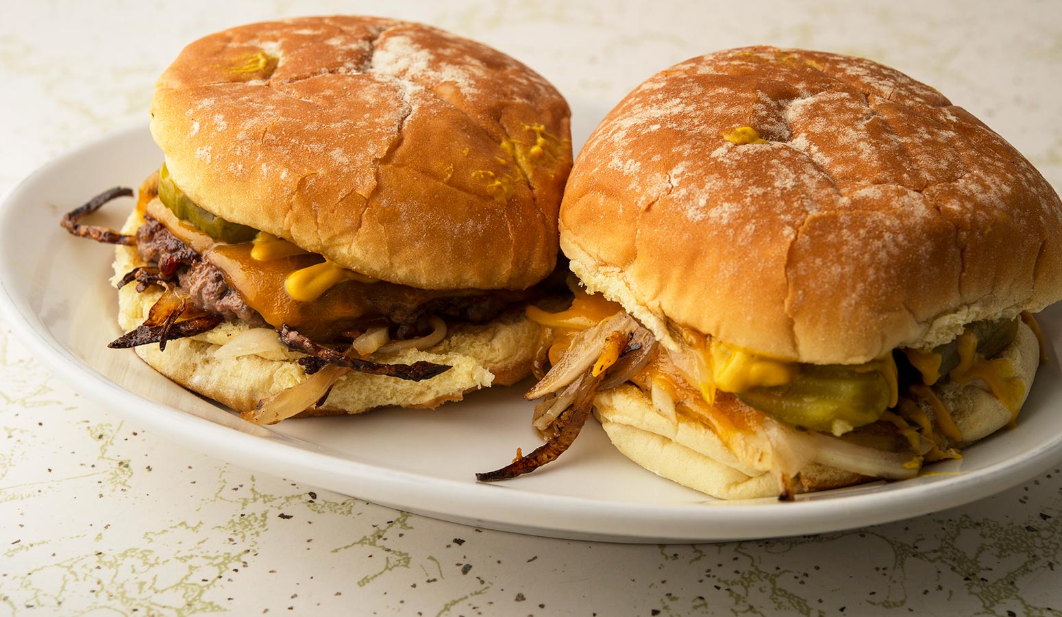 A couple of Oklahoma onion burgers on a plate. 