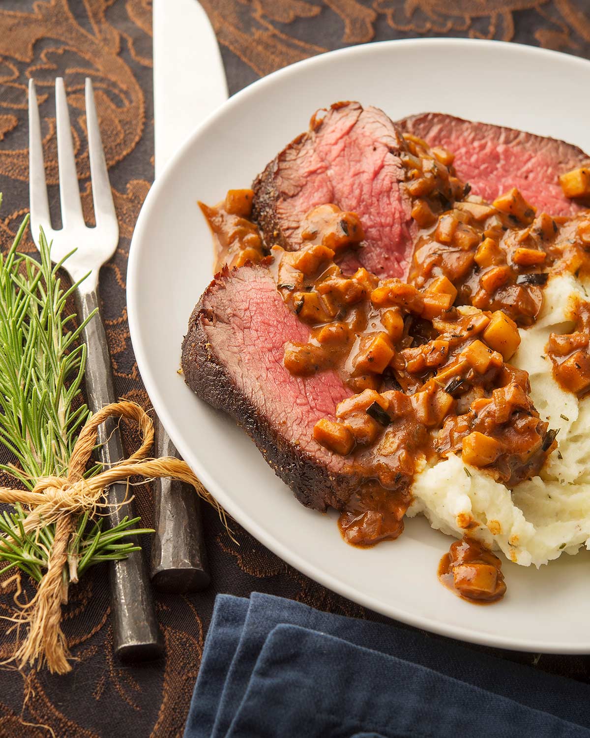 A mushroom sauce for steak on a venison steak with mashed potatoes.