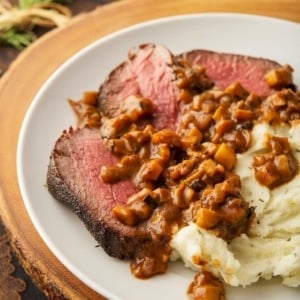 Venison with a French mushroom sauce on a plate