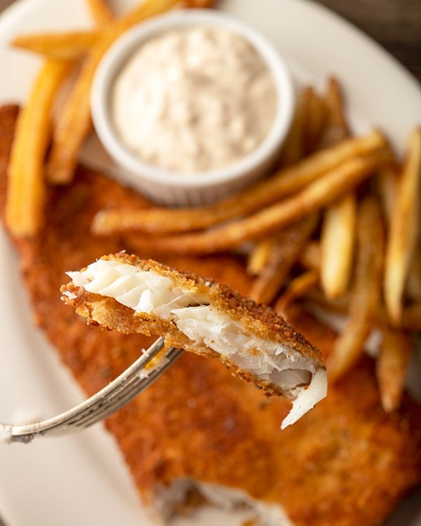 Eating a piece of fried flounder