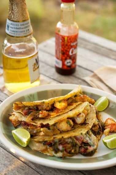 Tacos gobernador with a beer and hot sauce