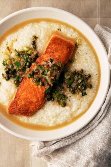 Salmon piccata served over grits