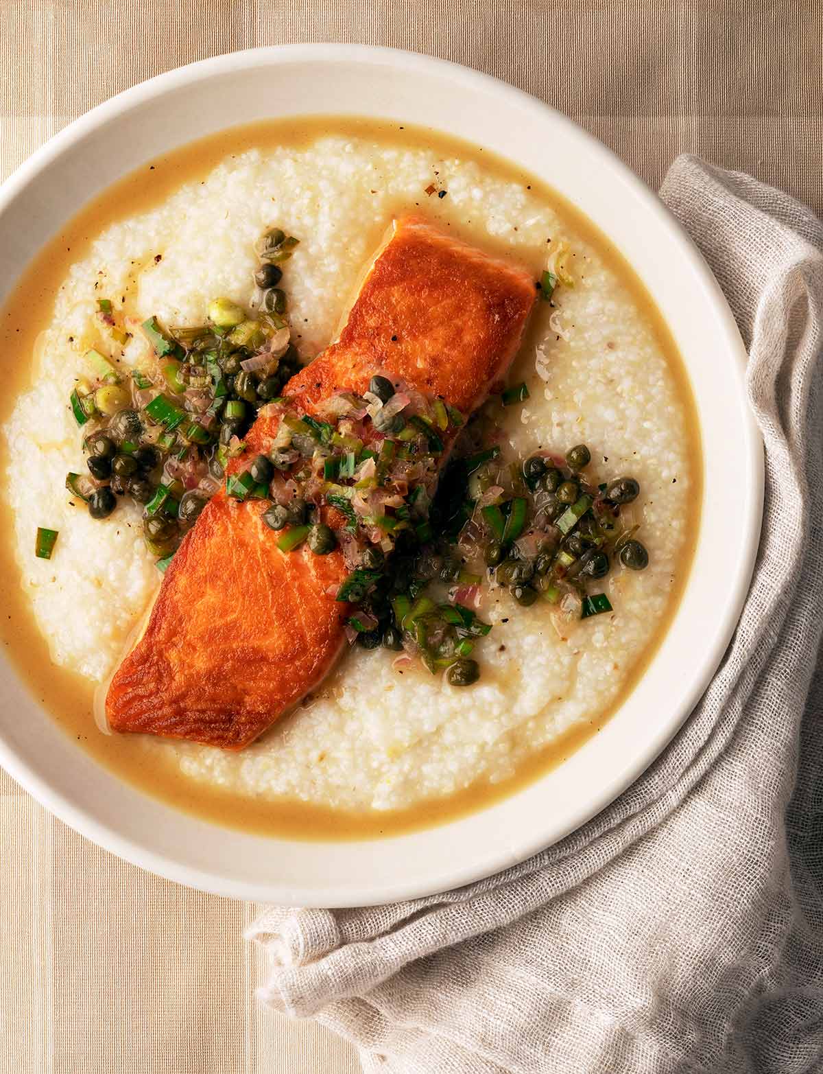 Salmon piccata served over grits
