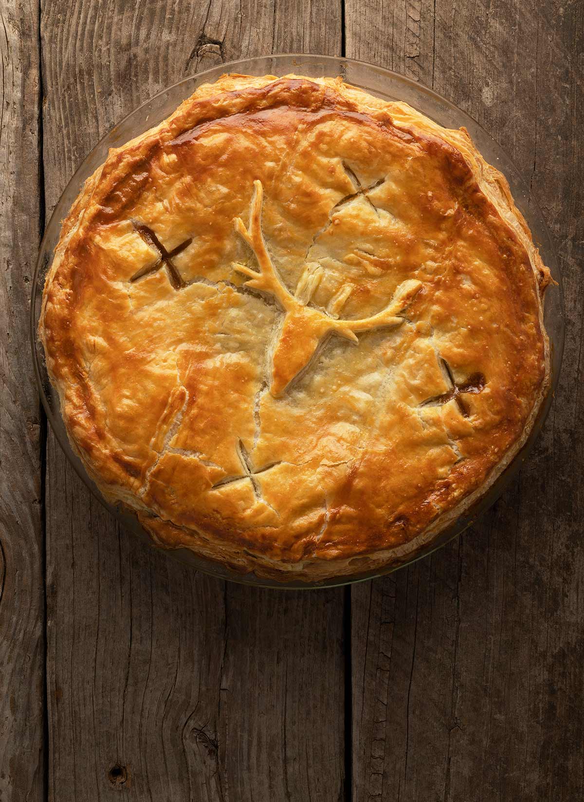 A venison and kidney pie uncut, on the table.