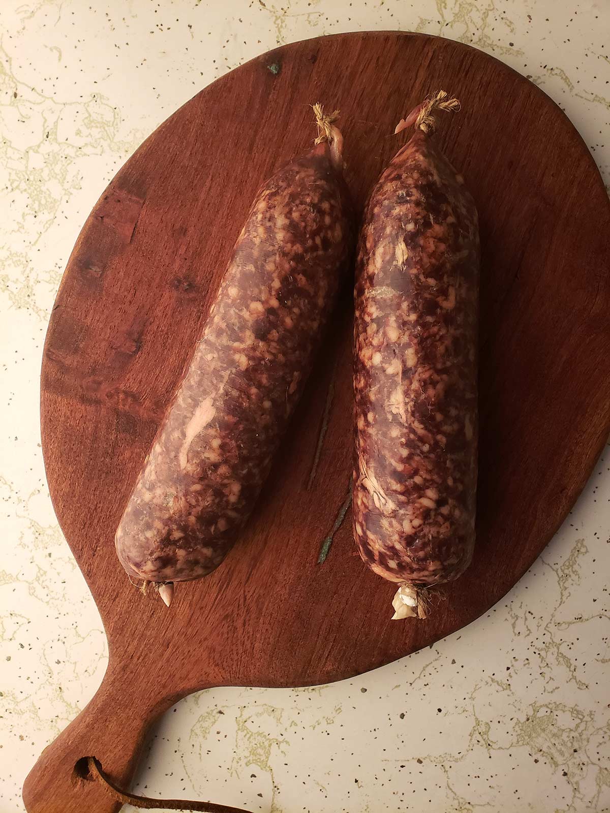 Uncooked cotechino on a cutting board