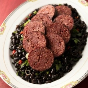 Sliced cotechino on a platter of beans