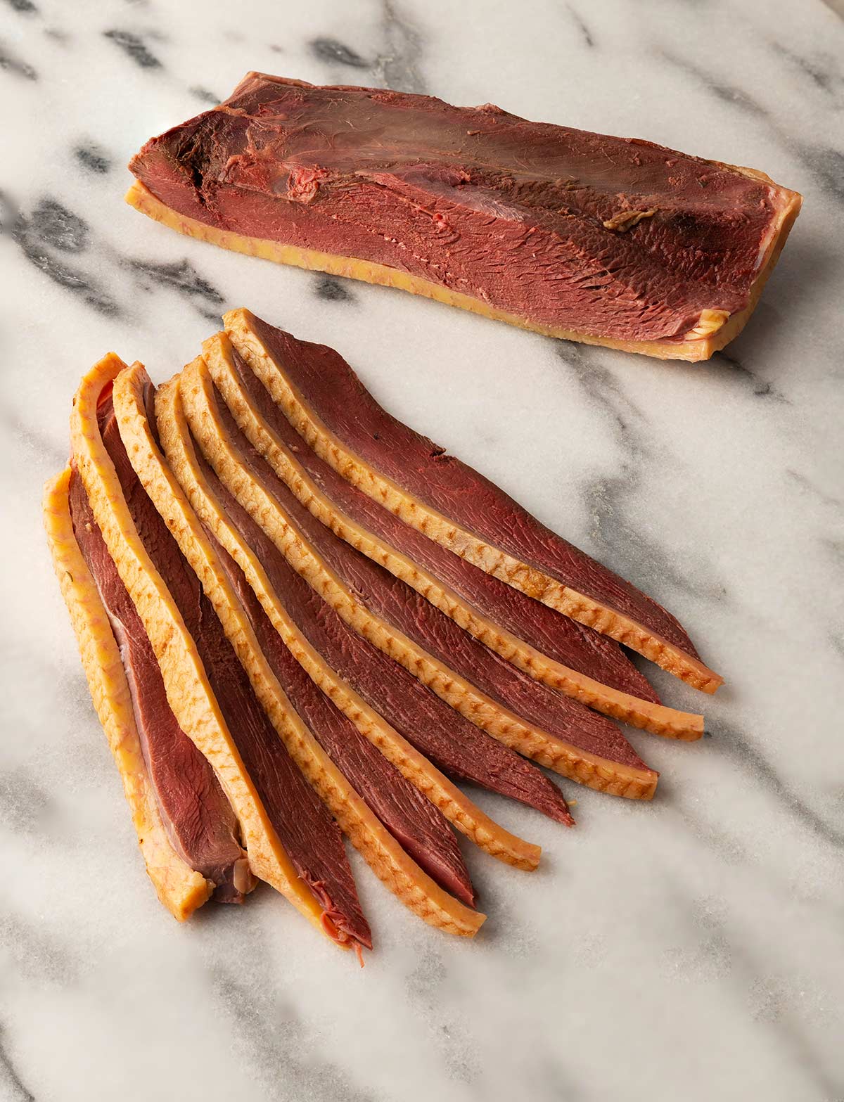 Slice of duck bacon on a marble board