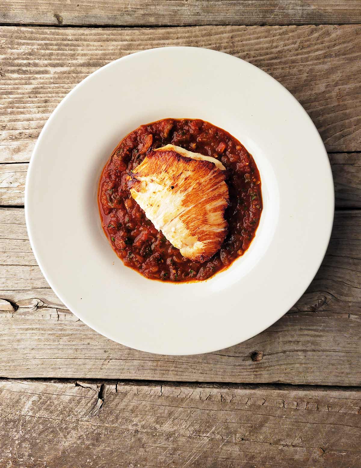 Halibut cheeks with saffron tomato sauce in a bowl