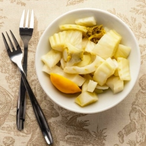 Pickled fennel in a bowl with appetizer forks