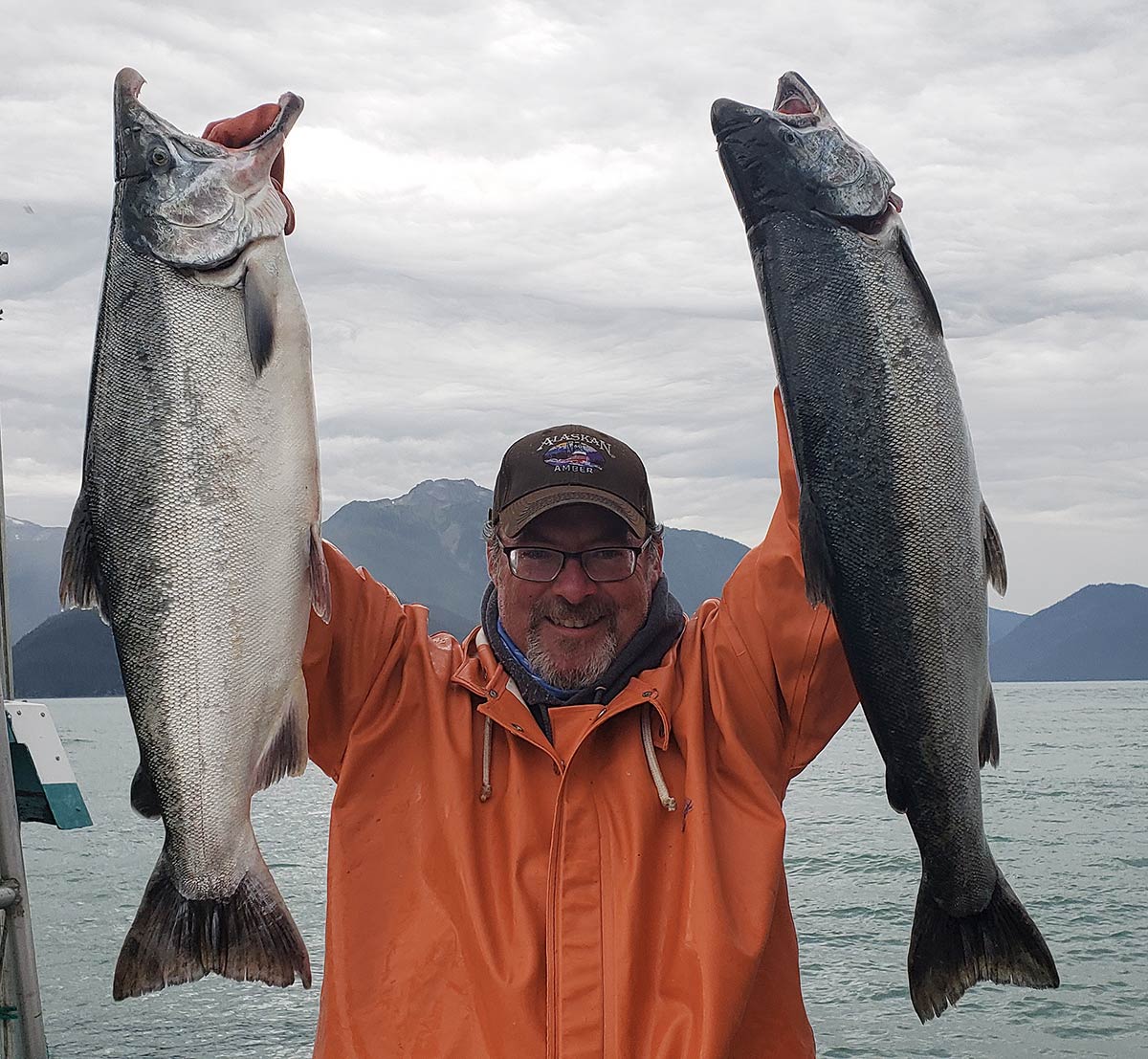 Hank Shaw holding up two coho salmon