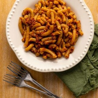 A bowl of pasta dressed with red pesto