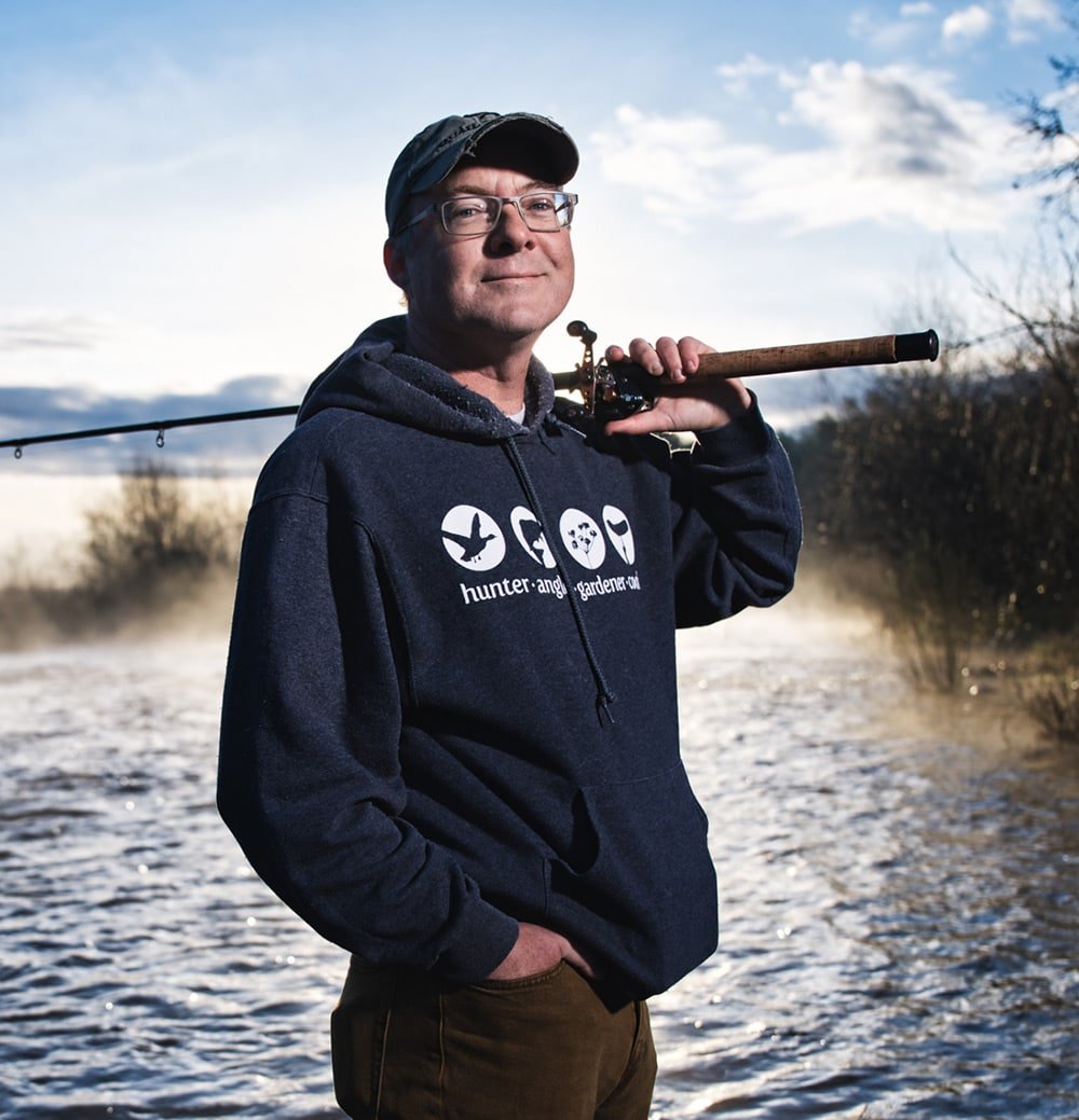 Hank Shaw holding a rod and reel in the American River