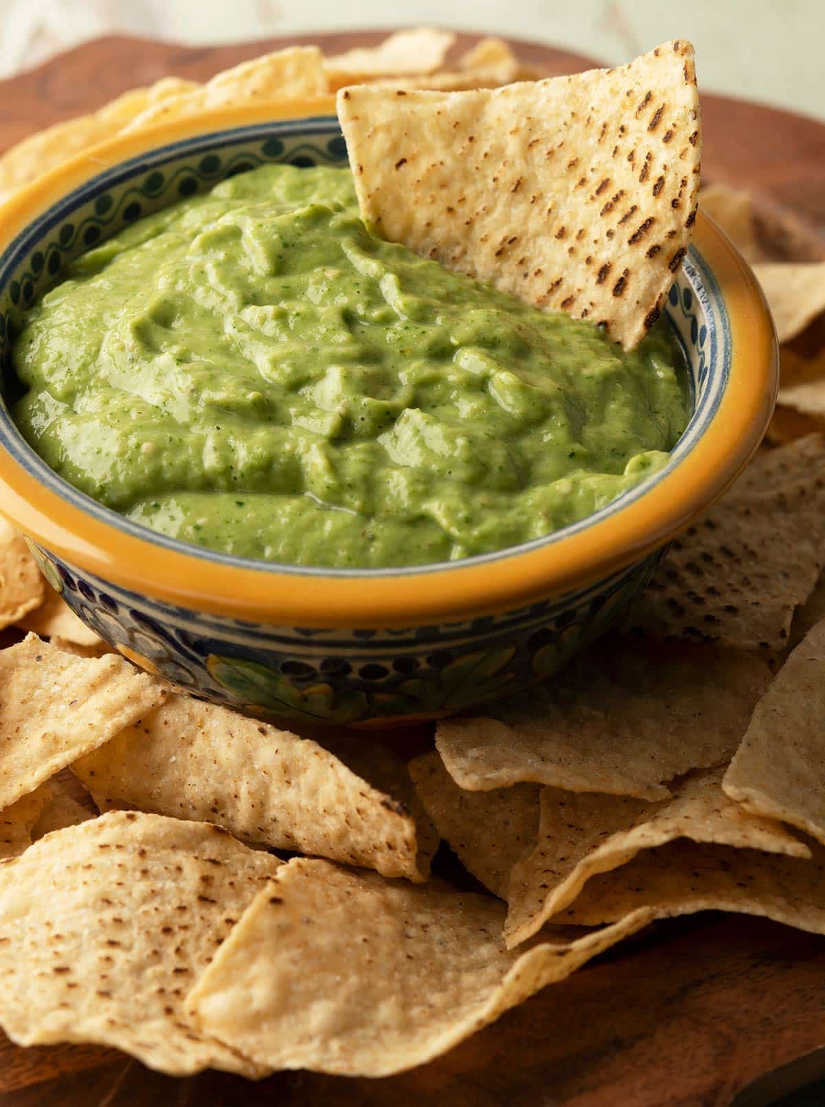 Avocado tomatillo salsa in a bowl with tortilla chips