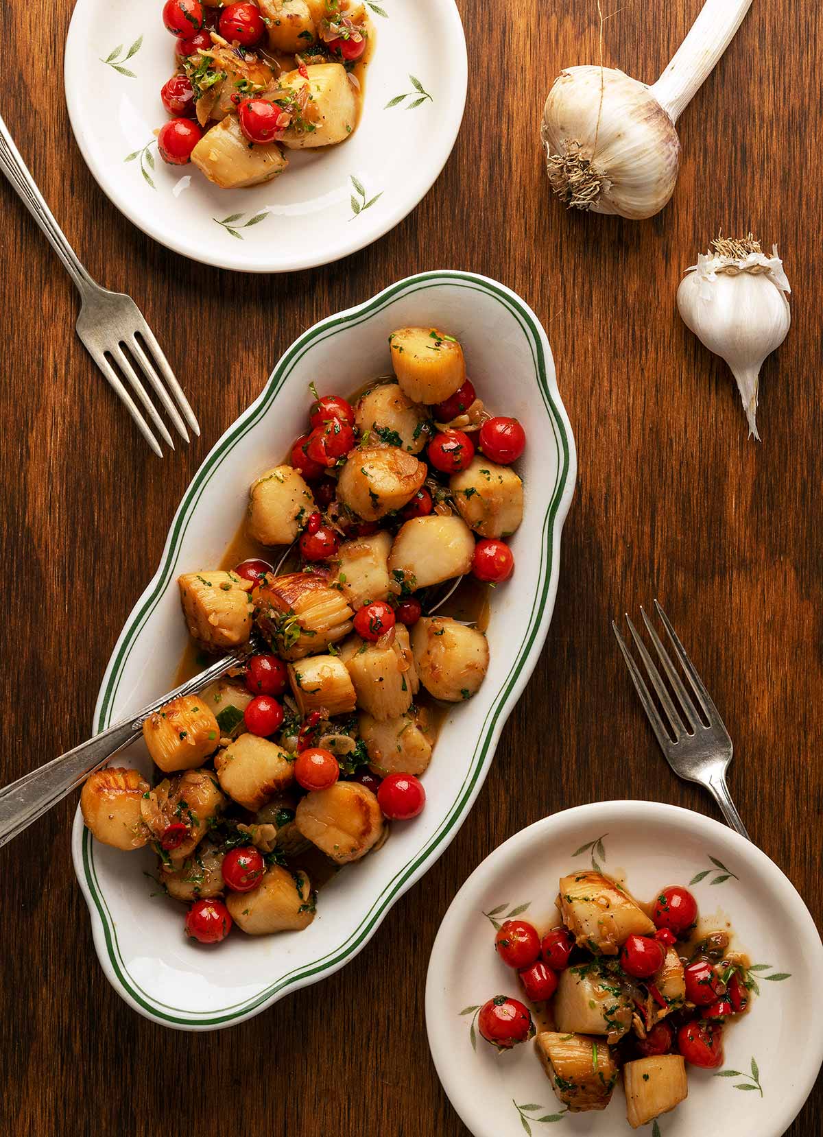 A bowl of scallop scampi with serving plates