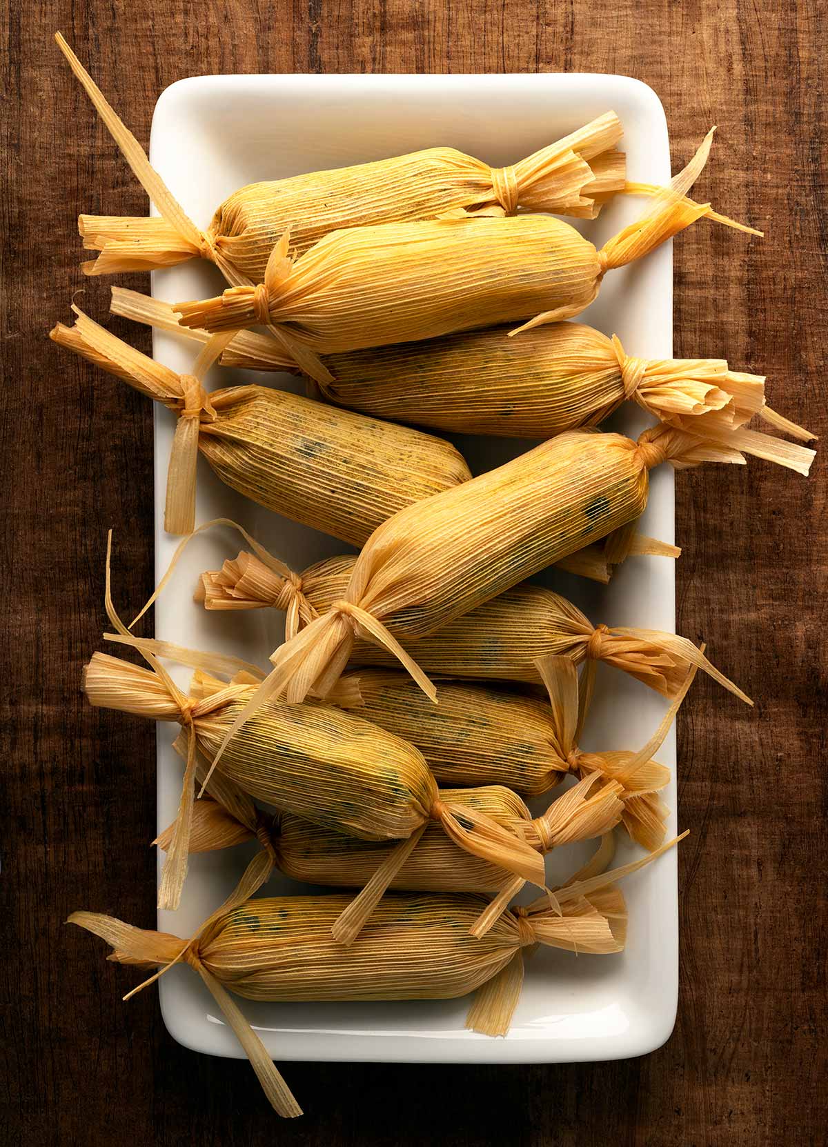 Chaya tamales in the husk on a plate