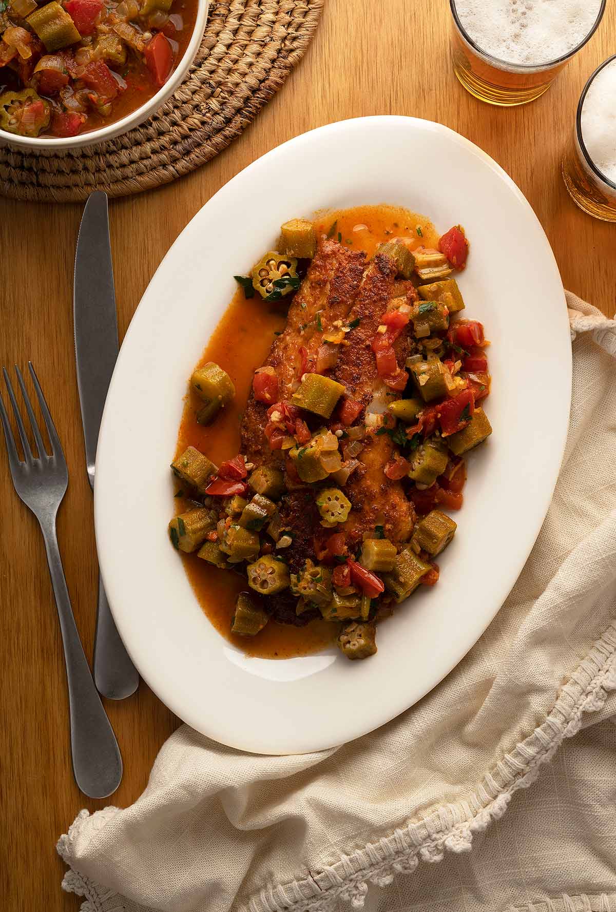 Okra stew served over fried fish on a plate