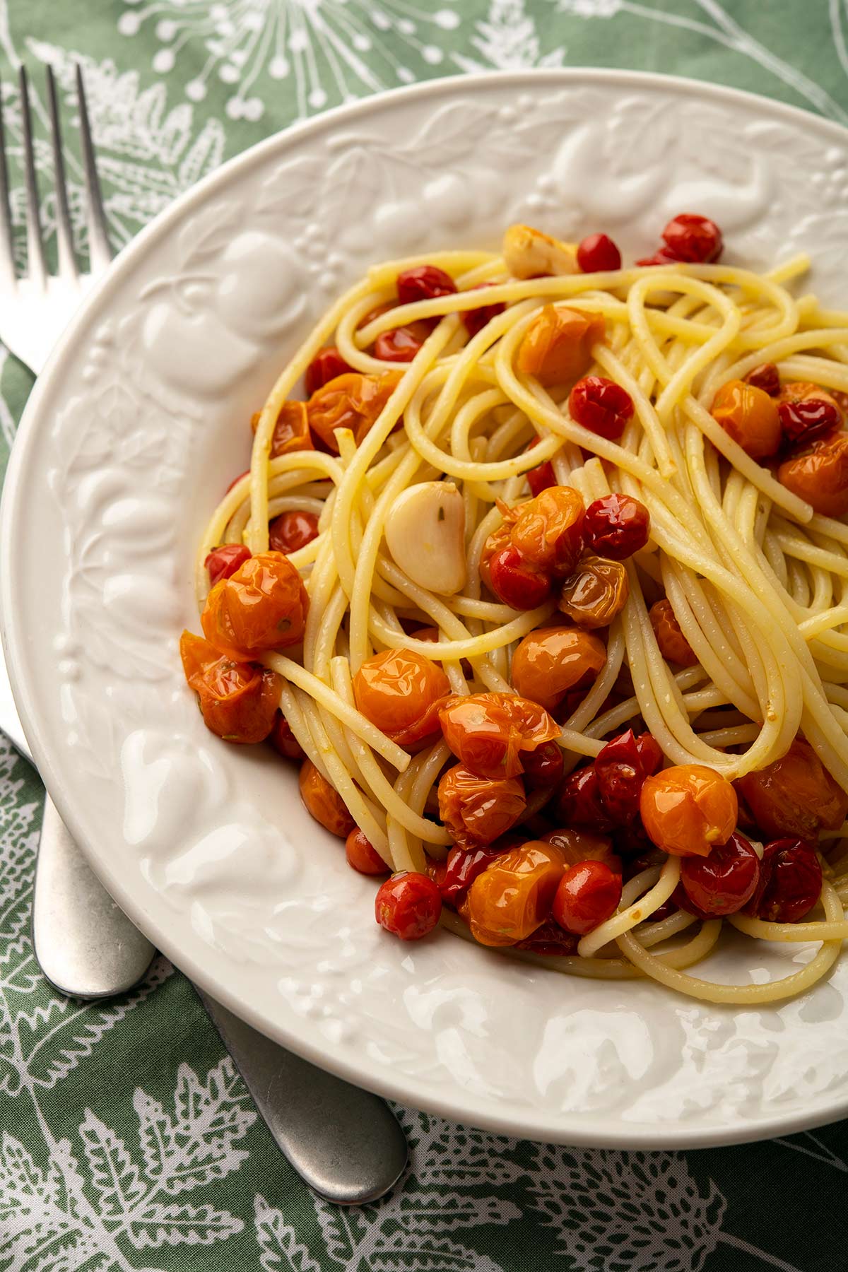 cherry tomato confit over pasta in a bowl