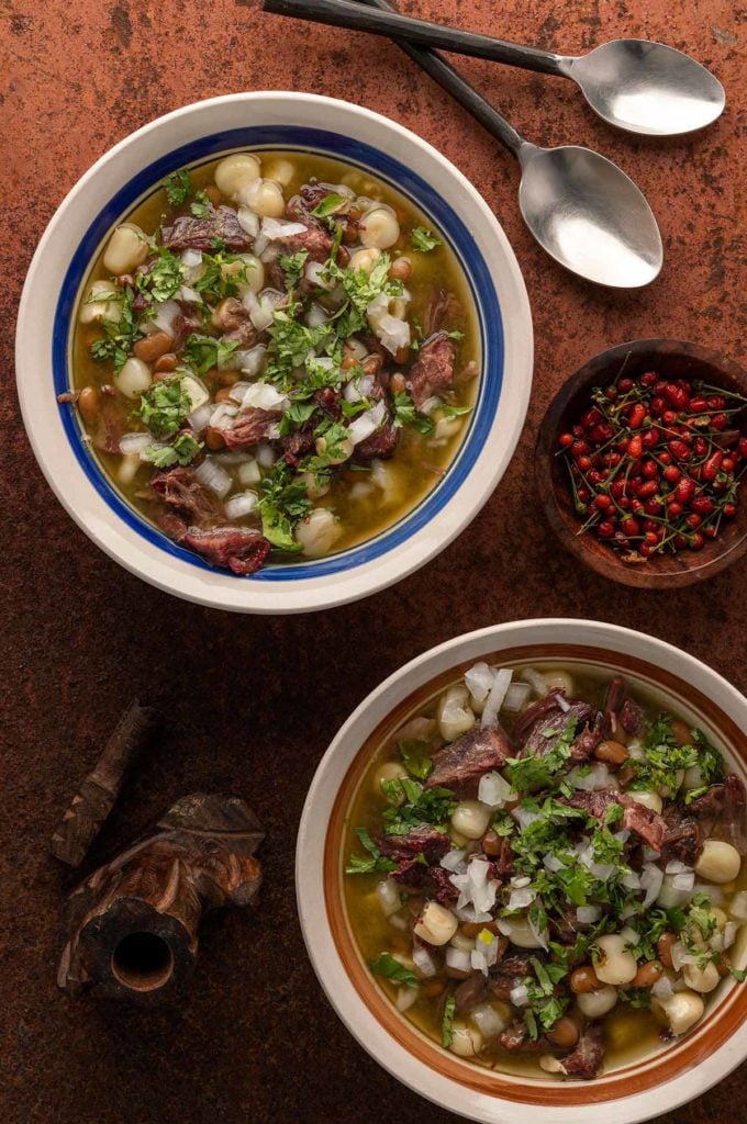 Two bowls of gallina pinta stew with chiltepin chiles. 