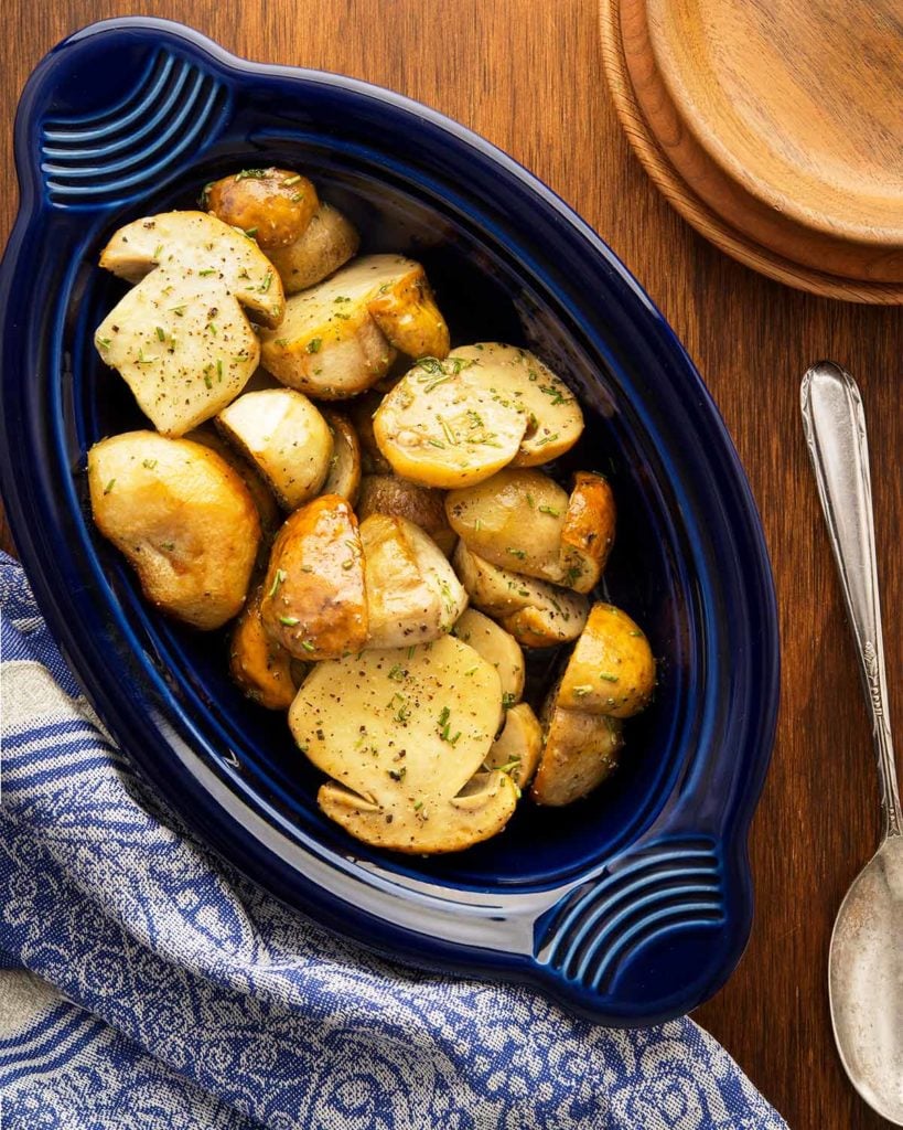 Roasted mushrooms with garlic and rosemary in a serving platter. 