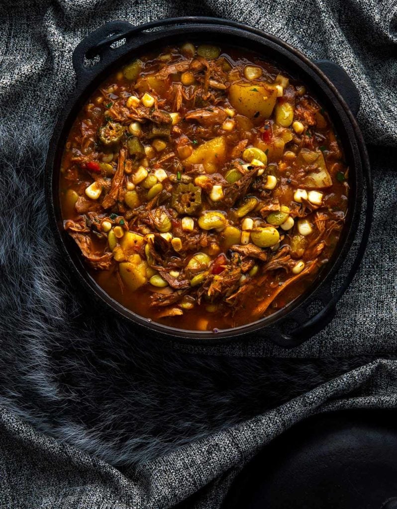 A pot of Brunswick stew on a dark background. 