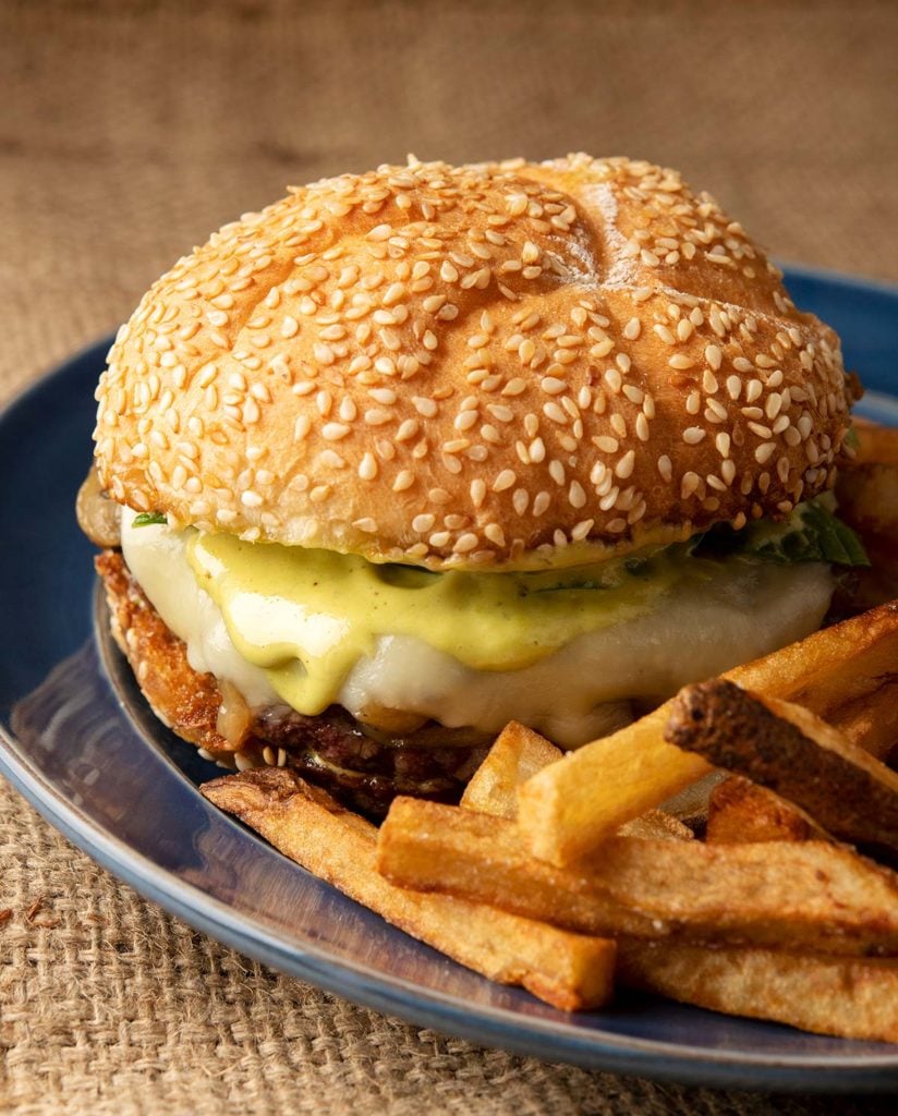 Closeup of duck burgers with fries on a plate. 