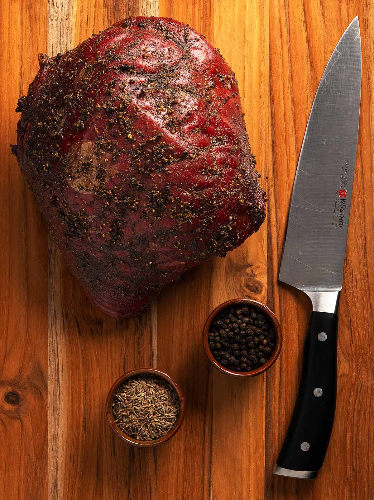 An elk roast resting on a cutting board, ready to be sliced. 